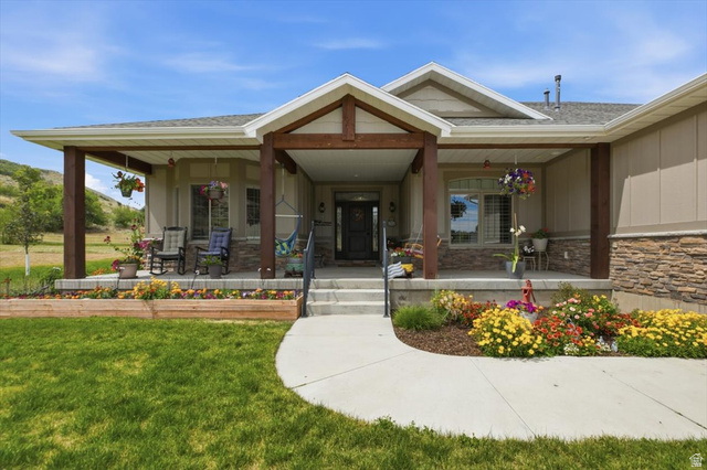 3123 East Riverdale Road Preston, ID 83263 - Photo 2 of 52 Inviting covered front porch with substantial wood-finish columns, stone veneer accents, and a concrete pathway. Porch swing will stay