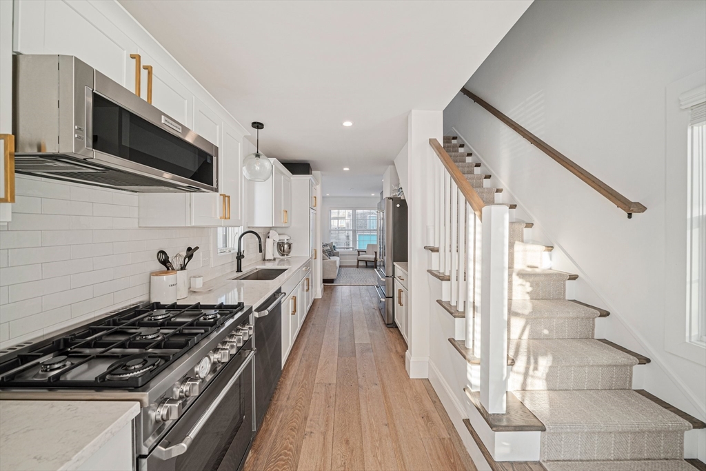 85 Glades Road Scituate, MA 02066 - Photo 9 of 42 a kitchen with stainless steel appliances a stove a microwave and cabinets
