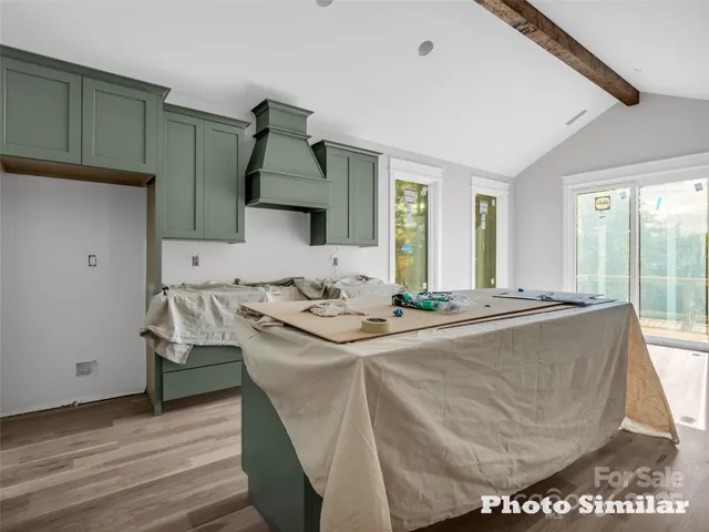 a living room with a sink and a stove with wooden floor