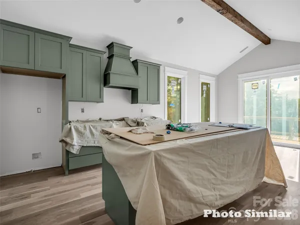 a living room with a sink and a stove with wooden floor