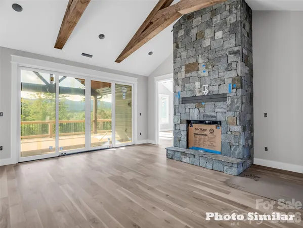 a view of an empty room with a fireplace and a window