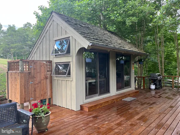 a view of a roof deck with table and chairs under an umbrella with wooden floor