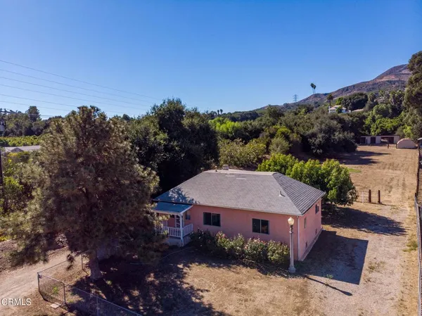 a aerial view of a house with a yard and mountain view in back