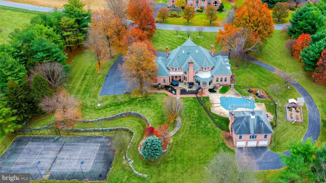 an aerial view of a swimming pool with outdoor seating and yard