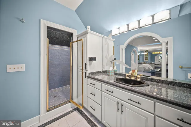 a spacious bathroom with a granite countertop sink mirror and shower