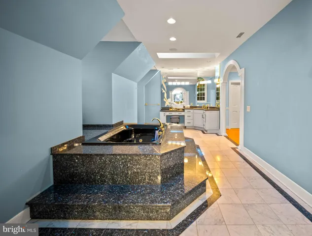 a bedroom with a bed and a lamp on the dresser