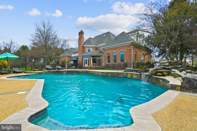 a view of a house with swimming pool and sitting area