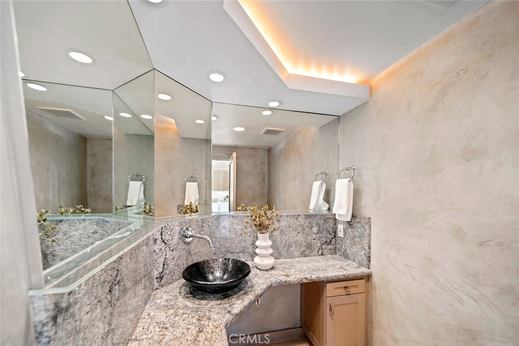 1907 Ocean Way Laguna Beach, CA 92651 - Photo 46 of 74 a bathroom with a granite countertop sink a toilet and a mirror