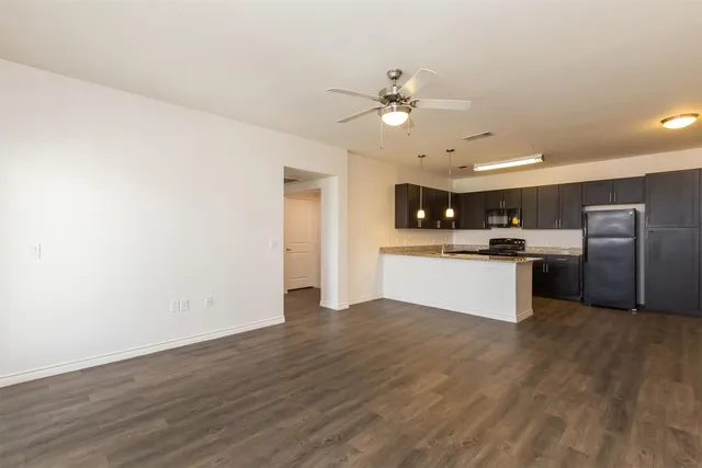 a view of kitchen with granite countertop cabinets and refrigerator