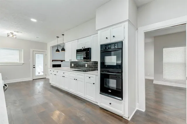 a view of an empty room with wooden floor and windows