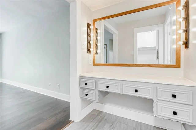 an empty room with wooden floor ceiling fan and window