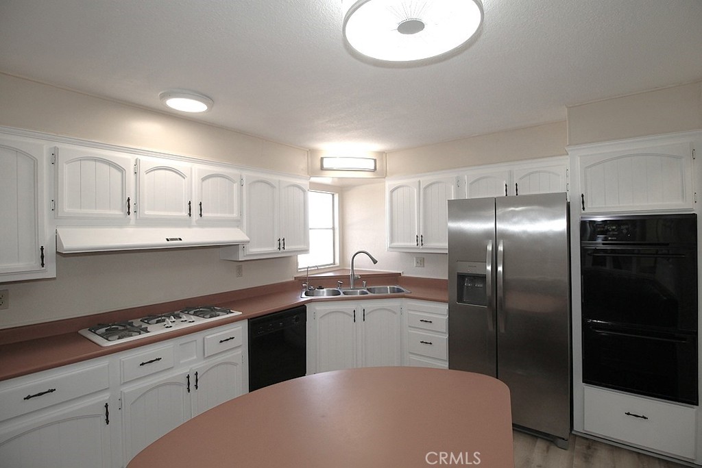 3750 Main Street Barstow, CA 92311 - Photo 18 of 39 a kitchen with kitchen island white cabinets stainless steel appliances and sink