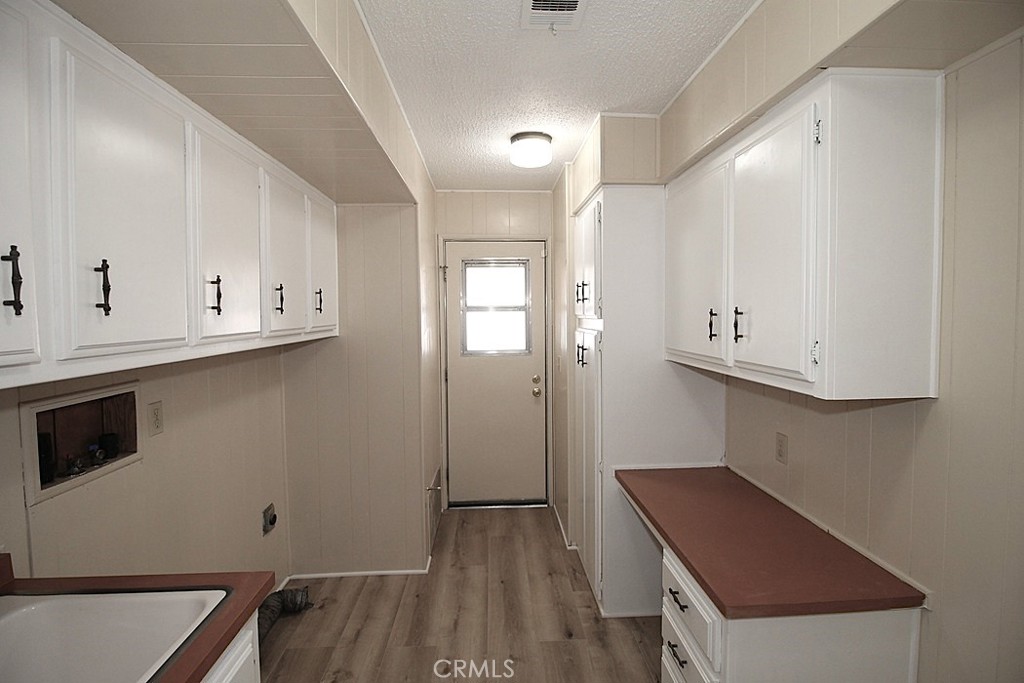 3750 Main Street Barstow, CA 92311 - Photo 27 of 39 a kitchen with cabinets appliances and a wooden floor