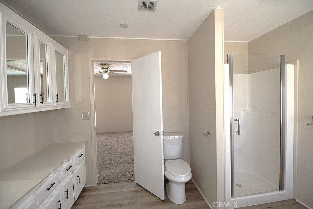 3750 Main Street Barstow, CA 92311 - Photo 37 of 39 a bathroom with a granite countertop toilet a sink and a mirror