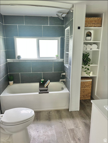 1050 West 100 North Provo, UT 84601 - Photo 8 of 16 Bathroom featuring a white bathtub with dark gray subway tile surround, a built-in shower niche, and a rain showerhead