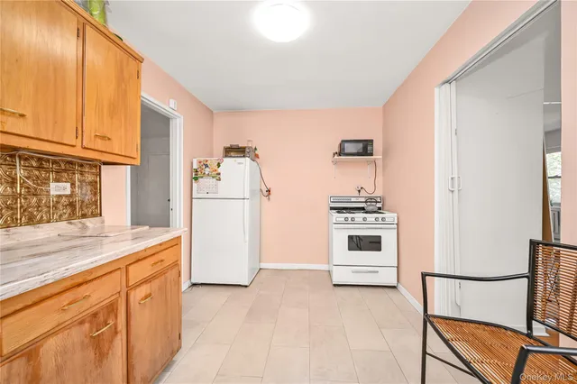 a kitchen with granite countertop a refrigerator and a stove top oven