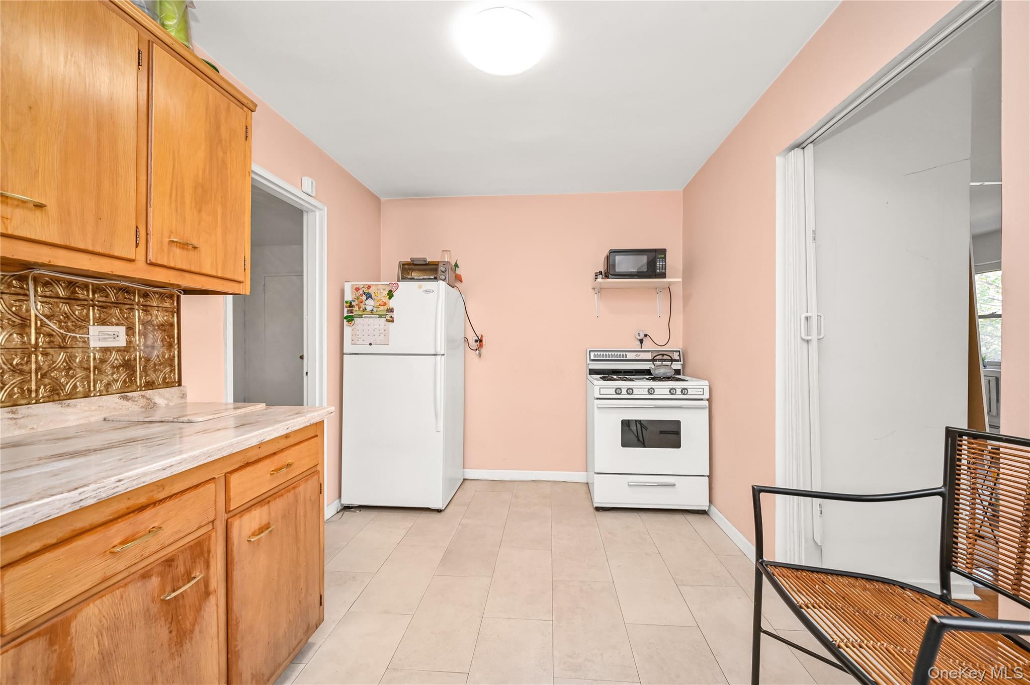 99-10 60th Avenue, Unit 3B Queens, NY 11368 - Photo 15 of 25 a kitchen with granite countertop a refrigerator and a stove top oven