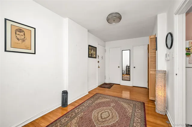 a view of a hallway with wooden floor and dining room