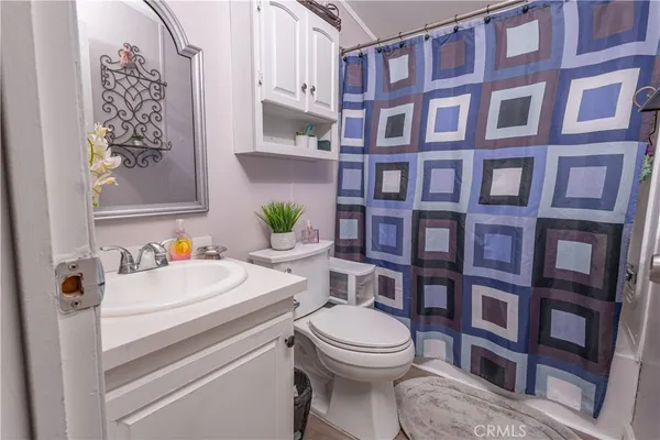 a bathroom with a sink a toilet and a shower curtain
