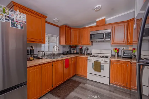 a kitchen with stainless steel appliances granite countertop a sink a stove and a refrigerator