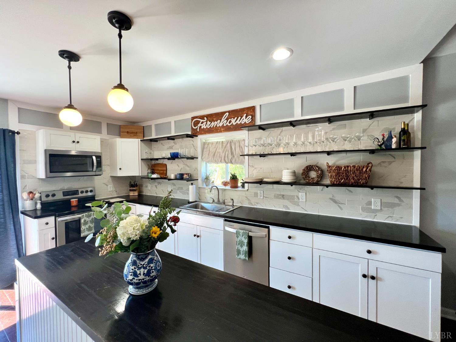 120 North Main Street Amherst, VA 24521 - Photo 8 of 62 a kitchen with stainless steel appliances granite countertop a sink a stove top oven a counter space and cabinets