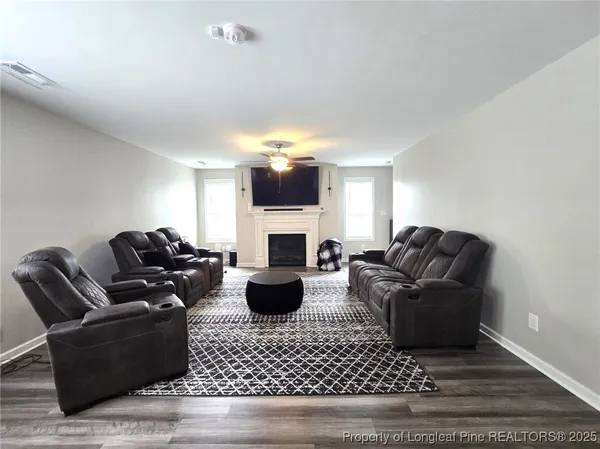 a living room with furniture a fireplace and a flat screen tv
