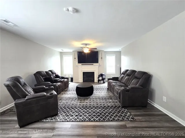 a living room with furniture a fireplace and a flat screen tv