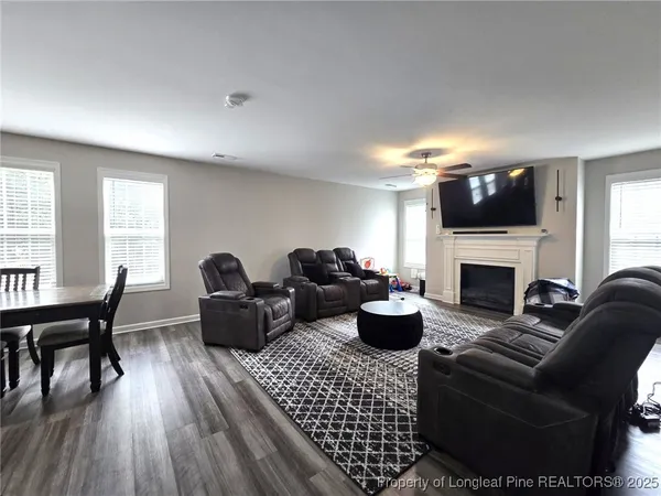 a living room with furniture a flat screen tv and a fireplace