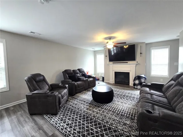 a living room with furniture a fireplace and a flat screen tv