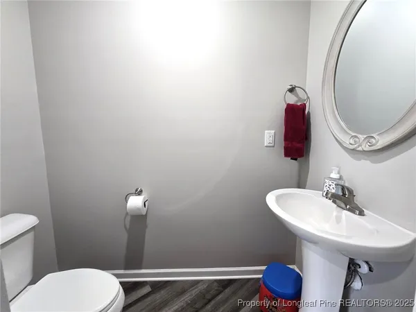 a bathroom with a toilet a sink and mirror