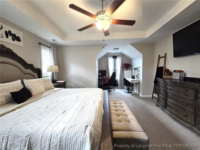 a bedroom with a bed and a flat tv screen on dresser