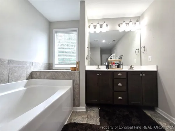 a spacious bathroom with a tub sink and mirror