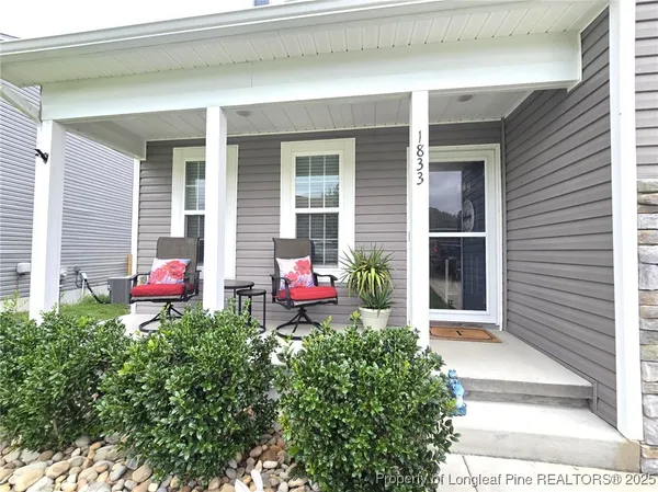 a house view with a chair and table sitting in front of a window