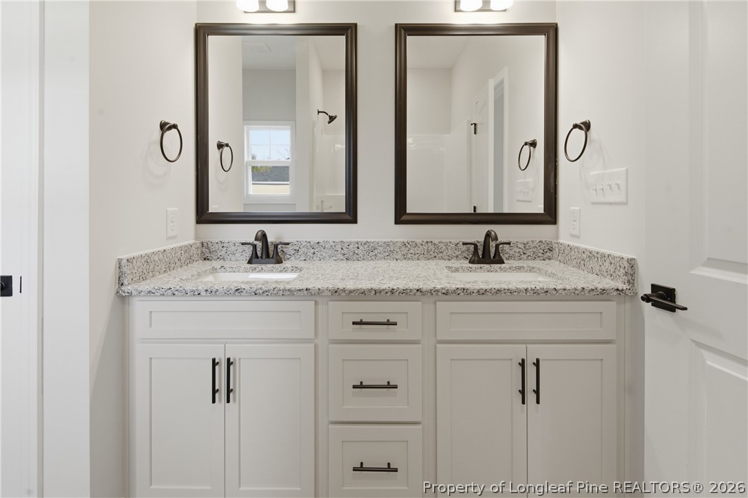1523 McBryde Lake Road Raeford, NC 28376 - Photo 14 of 32 a bathroom with double sink and a mirror