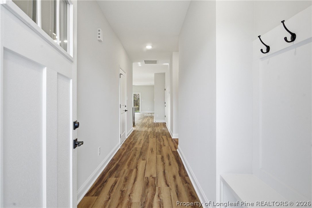 1523 McBryde Lake Road Raeford, NC 28376 - Photo 3 of 32 a view of a hallway with wooden floor and staircase
