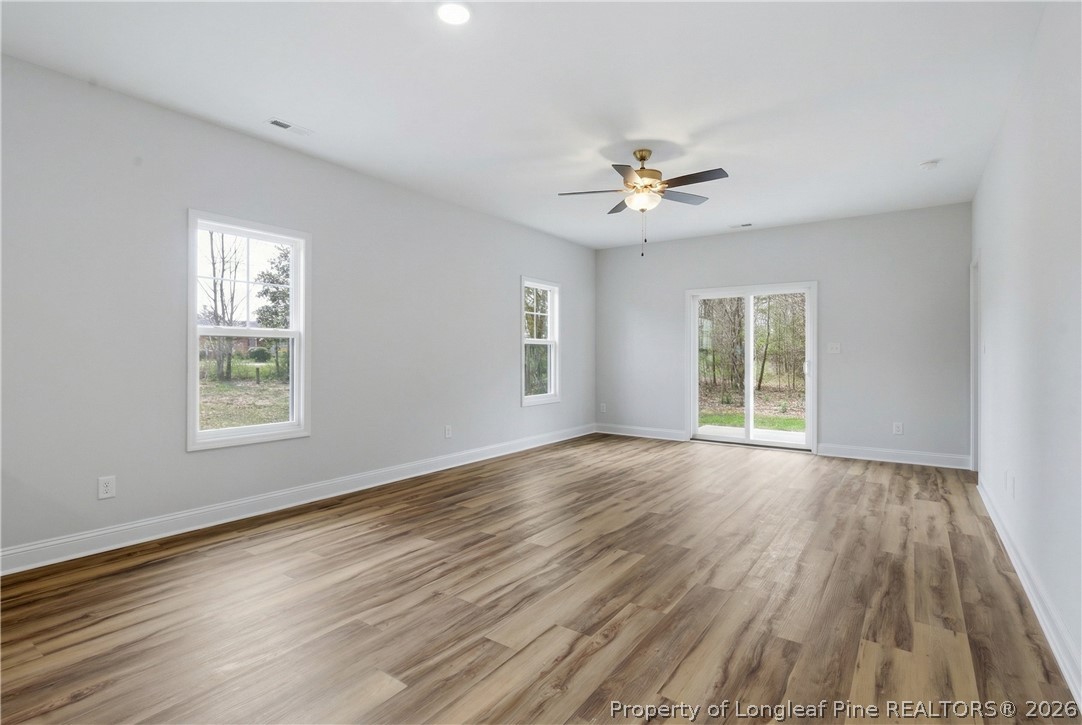 1523 McBryde Lake Road Raeford, NC 28376 - Photo 6 of 32 a view of an empty room with a window and wooden floor
