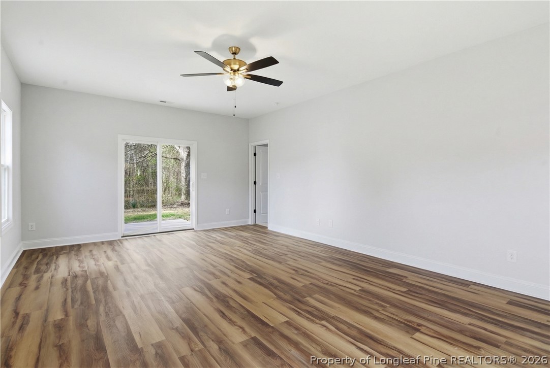 1523 McBryde Lake Road Raeford, NC 28376 - Photo 8 of 32 a view of empty room with wooden floor and fan