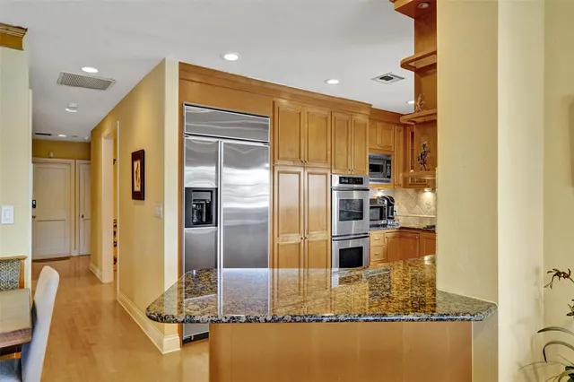 a bathroom with a granite countertop double vanity sink and a mirror