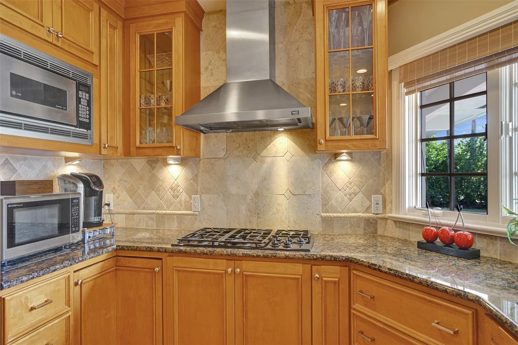 7 Saranac Road Sea Ranch Lakes, FL 33308 - Photo 40 of 93 a kitchen with granite countertop a sink and a stove next to a window