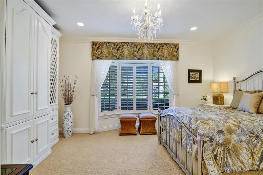 7 Saranac Road Sea Ranch Lakes, FL 33308 - Photo 52 of 93 a spacious bedroom with a bed and a chandelier