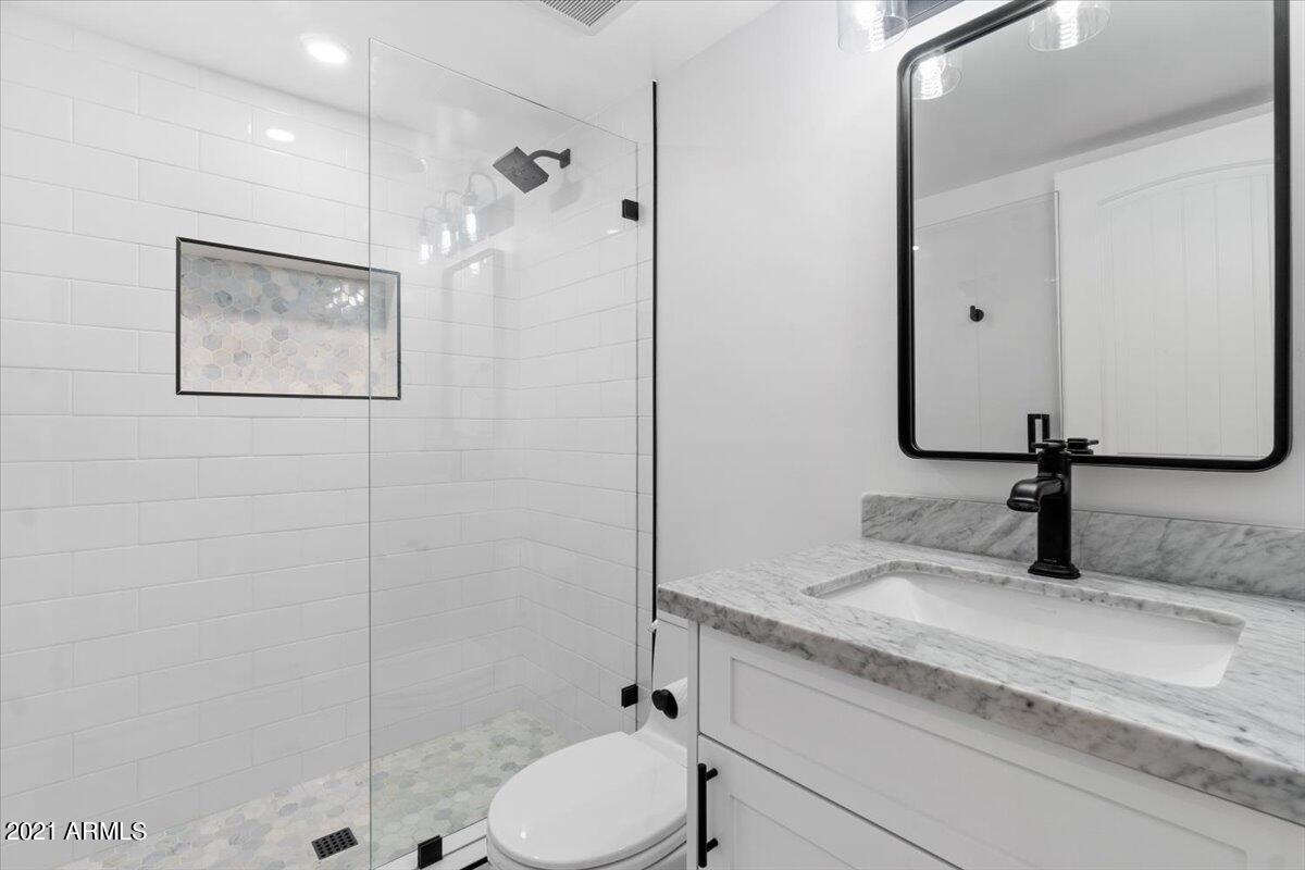 4041 East Camelback Road, Unit 2 Phoenix, AZ 85018 - Photo 19 of 25 a bathroom with a granite countertop sink toilet and shower