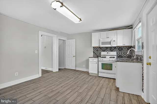 a kitchen with granite countertop a stove and cabinets