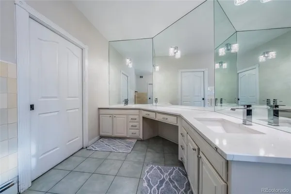 a large bathroom with a double vanity sink a mirror and a bathtub