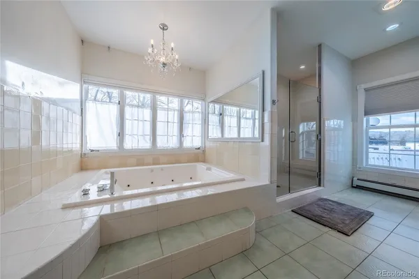 a spacious bathroom with a tub sink and mirror