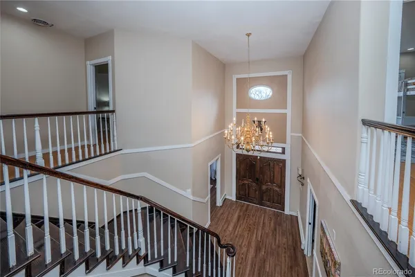a view of a hallway with wooden floor and stairs