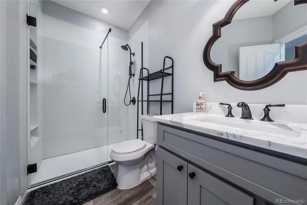 a bathroom with a granite countertop toilet sink and shower