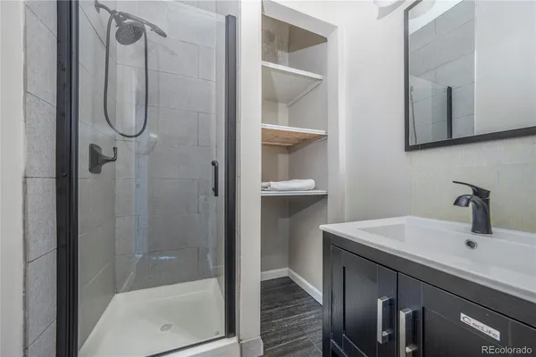 a bathroom with a shower sink and mirror