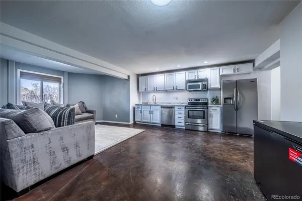 a living room with furniture and kitchen
