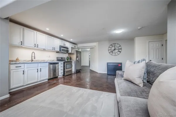 a living room with furniture and kitchen view