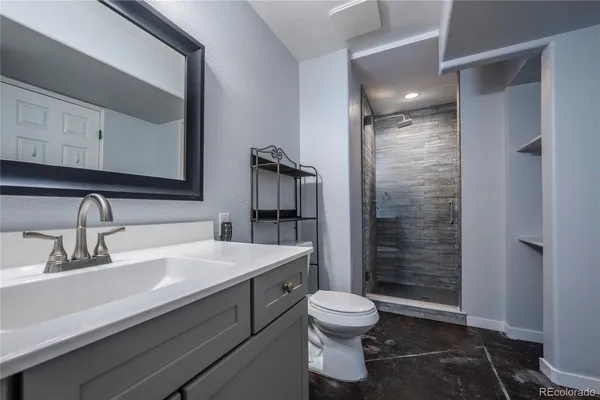 a bathroom with a sink a toilet and shower